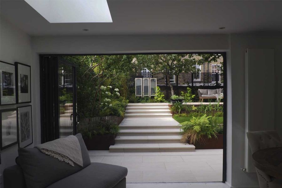 Faro porcelain tiles used indoors and outdoors to obtain a seamless look, with patio leading to porcelain steps on two levels.