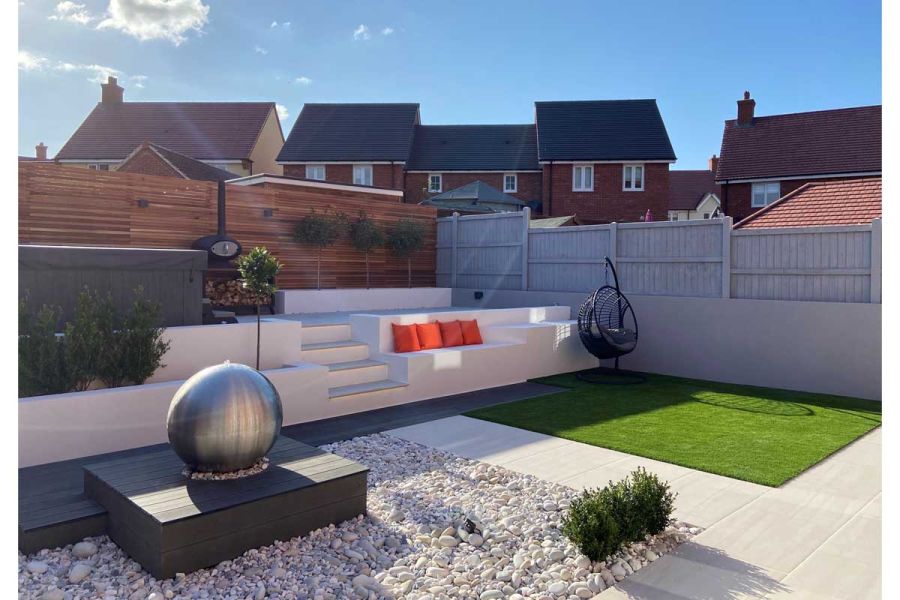 Low maintenance garden with terrace leading to a hot tub and raised porcelain patio.