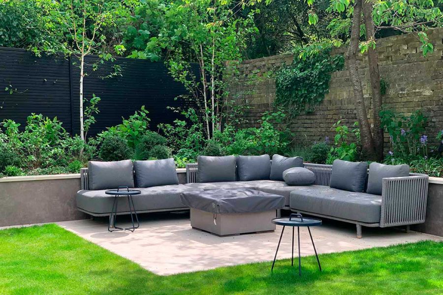 Large modular rattan furniture garden set in a green, outdoor area paved with Faro vitrified tiles supplied by London Stone.