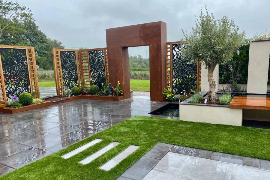 Metal garden screens and flat arch entrance enclose Florence Storm Italian porcelain with artificial lawn. Design by Landtech.