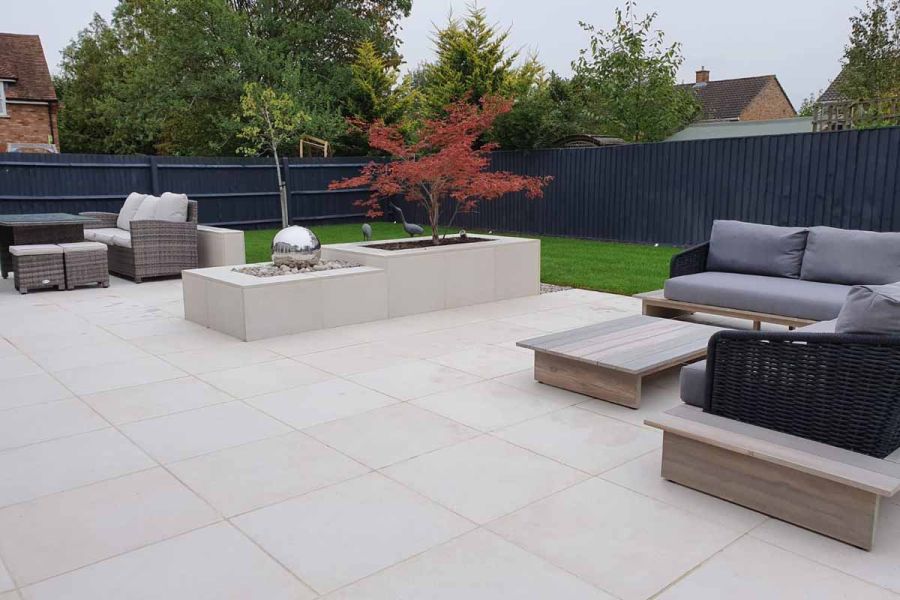 2 sets of garden furniture on Florence White Porcelain patio, with raised treepit and water feature. Design by Sue Gilbert.