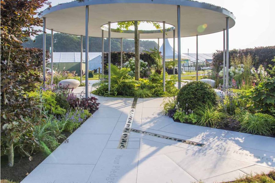 Cancer Research Legacy garden by Neil Sutcliffe, RHS Tatton 2021, paved in Florence white porcelain slabs with metal pergola.