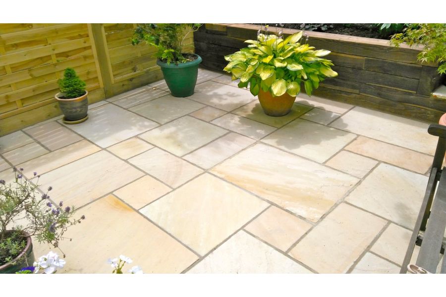 3 pots on small Mint Indian sandstone patio of project pack paving, laid with wide joints making feature of different slab sizes.