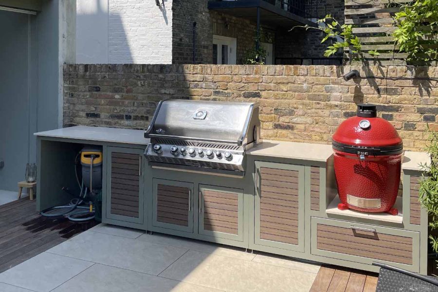 Orange egg BBQ and Kercher washer in niches in outdoor kitchen units, set against wall and faced with Chestnut composite battens.