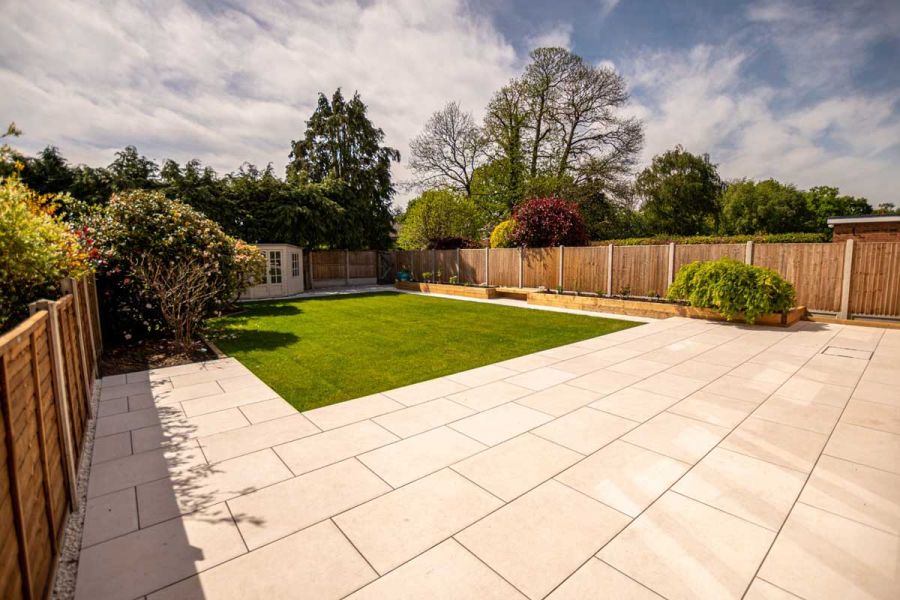 Large Florence white Porcelain rectangle slabs laid in stretcher bond pattern looking out across a grassed rear garden.