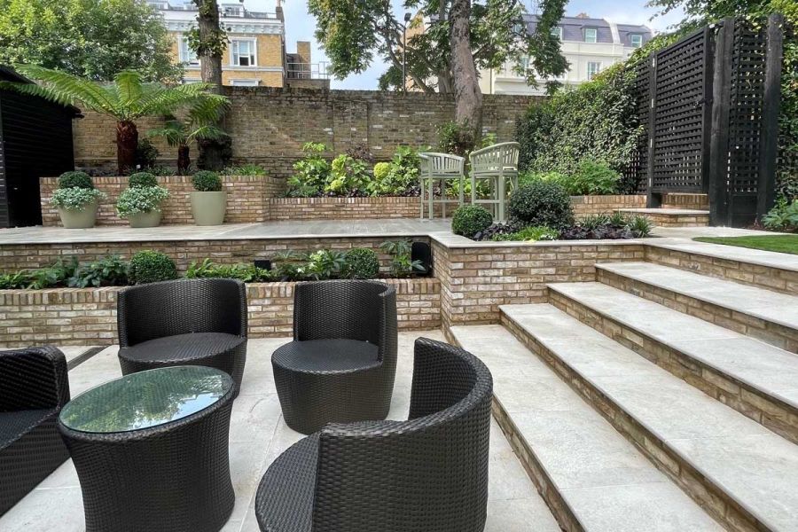 Garden on 2 levels, with Gea porcelain steps and paving with brick retaining walls and risers. Built by Hampstead Garden Design.