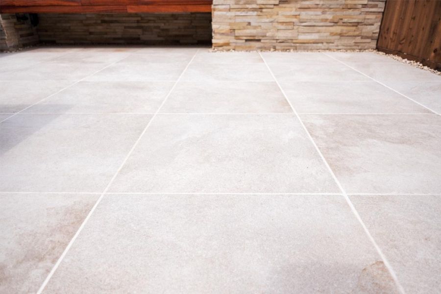 Gea Porcelain Paving slabs laid in a square grid pattern and pointed with white patio grout, designed by Vu Garden Design.