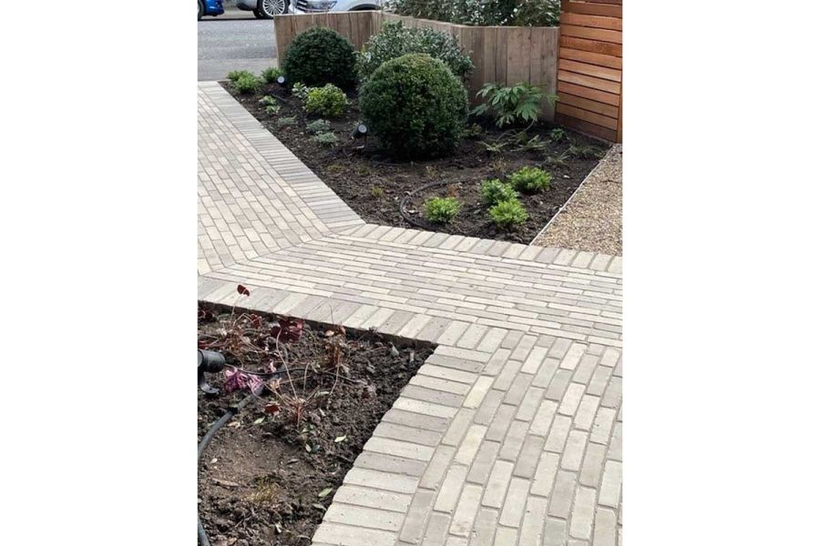 Gromo Antica brick paving runs from street, between planted beds, up front garden to meet matching path coming in at a right angle.