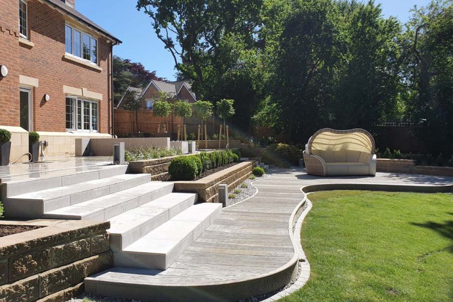 Terraced beds and Florence Grey porcelain steps ascend from curved decking. Design by Sue Gilbert. Built by Habitat Landscapes.