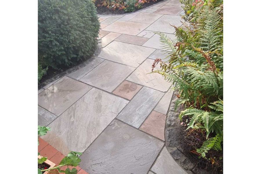 Autumn Brown Indian sandstone path, slabs cut to curved edges of flower beds outlined in granite sets. By Cypress garden services