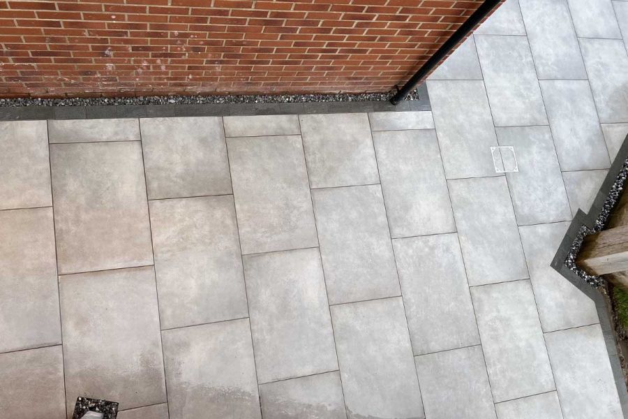 Birds eye view of a Venetian Grey Porcelain patio laid with 900x600 sized pavers in a classic stretcher bond pattern.