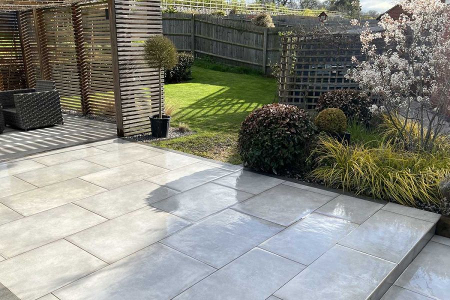 Venetian Grey Porcelain patio leading towards an outdoor garden structure constructed from slatted timber battens.