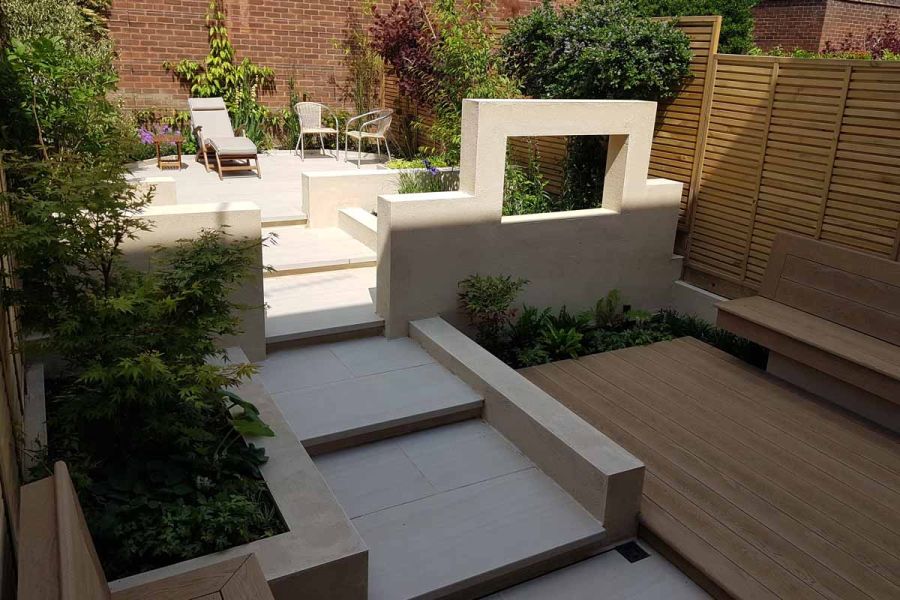 Wide steps created with Faro Porcelain Paving seen in the shadows, leading up to patio area in the sun.