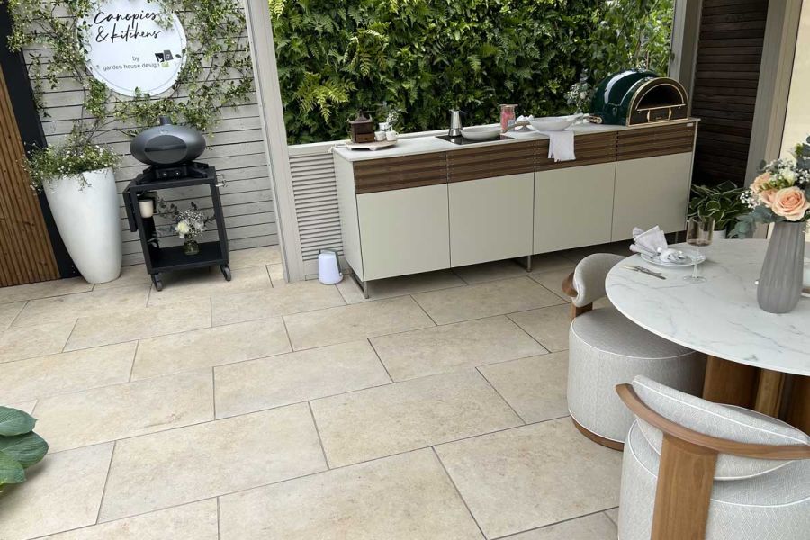 Outdoor kitchen and dining area featuring a circular table and modular work top, all paved in Jura Beige Porcelain.