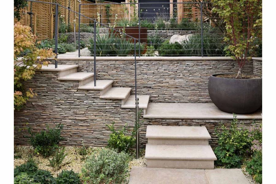 Jura Beige Smooth limestone paving adorned with cobblestone-clad steps leading up to corten water feature.