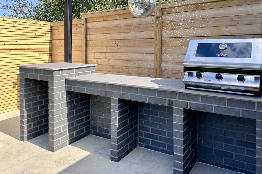 Large brick built barbecue with an inbuilt gas burner and Jura Grey Porcelain slabs used as work tops.