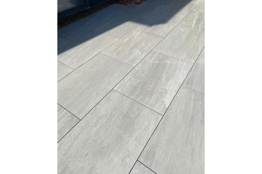 Kandla Grey outdoor porcelain paving, laid running bond by Landspace By Design, shows markings similar to Indian sandstone.