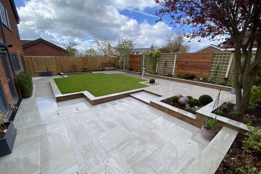 Large Kandla Grey Porcelain patio leading up to a raised terrace area with matching steps and coping stones.