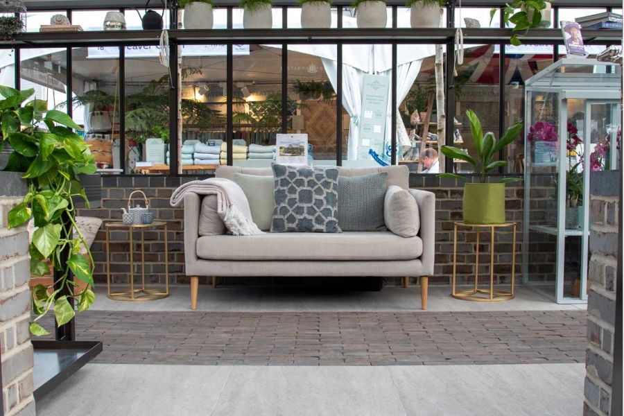 Strip of Lugano Clay Pavers runs past sofa and tables against wall beneath windows on Hartley Botanic trade stand, Chelsea 2022.
