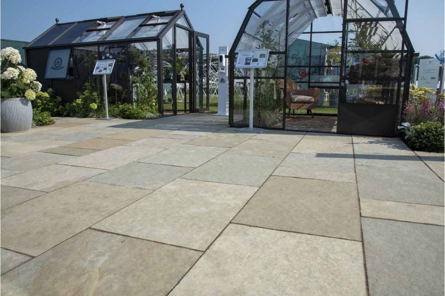 2 Llevelo metal framed greenhouses in area of 900x600 Kota Brown limestone paving on flower show trade stand.