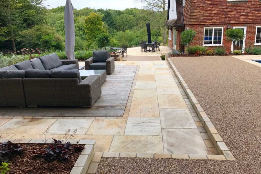 Luxury modular lounge set sits on outdoor rug on Mint Indian Sandstone paving, 1 brick depth down from resin-bonded pool surround.