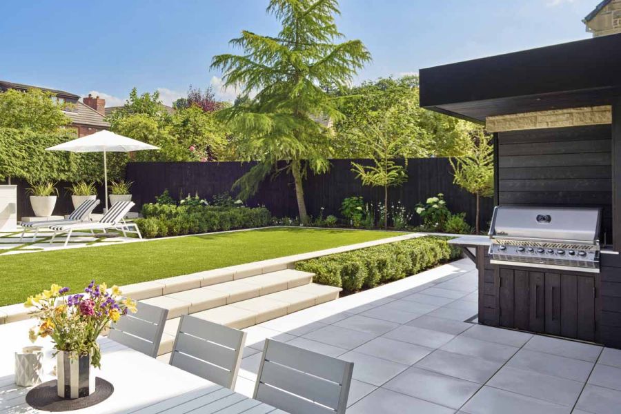 Contemporary garden featuring everything required for outdoor living: cooking and dining areas, swimming pool and outdoor tv.