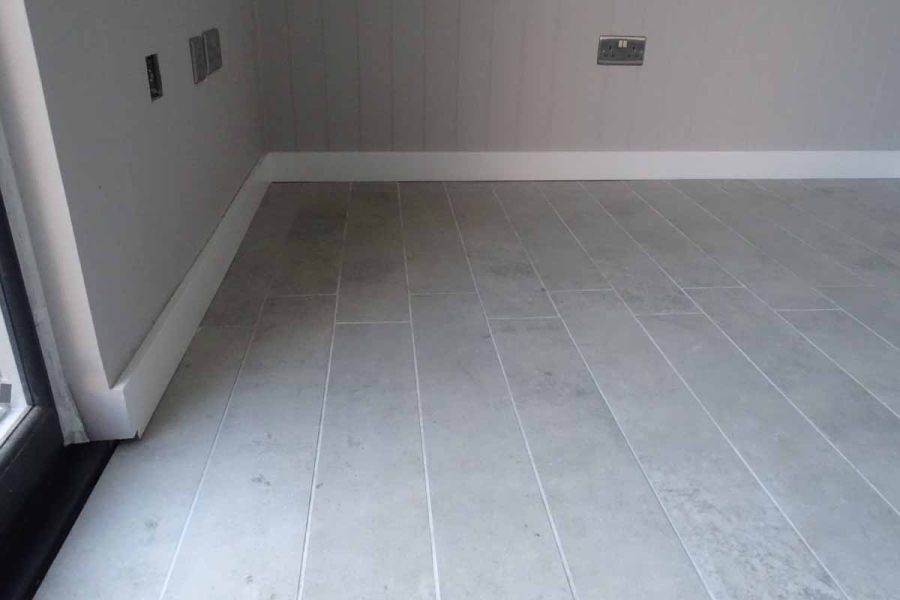 Light Grey Porcelain Plank paving laid in garden outbuilding, pointed with white coloured grout suitable for porcelain paving.