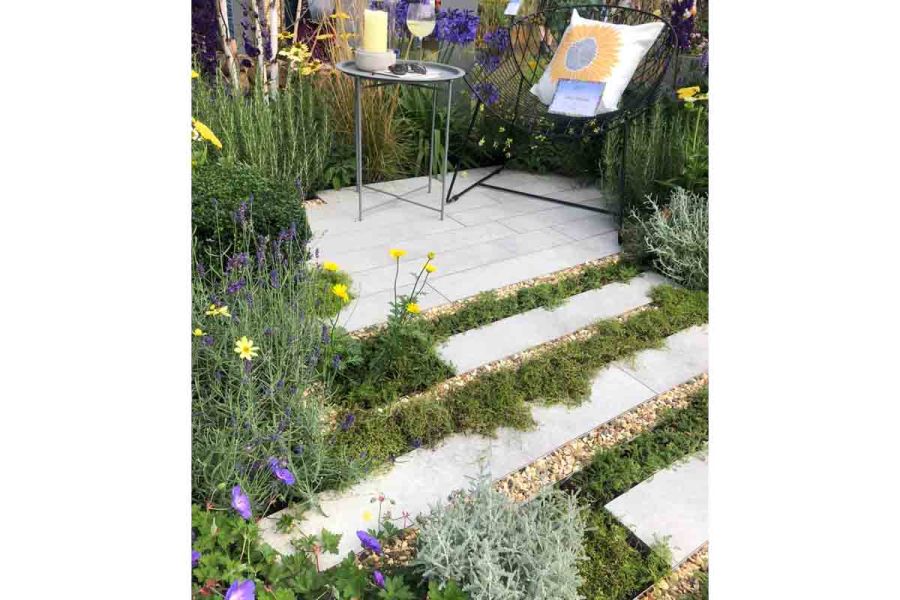 Striped path of Light Grey porcelain planks, gravel and ground covered in colourful plants and moss.