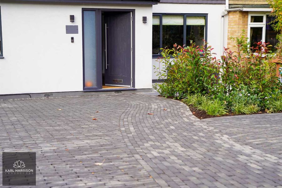 Lucca clay pavers laid in contrasting paving patterns leads to modern front door in design by Karl Harrison.