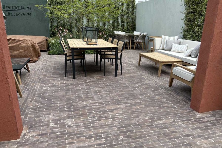 Sets of furniture arranged on Verona Dutch clay pavers on Indian Ocean stand at RHS Chelsea. Design by Max Parker Smith.