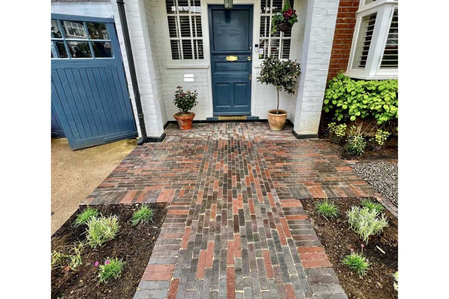 Wet Bergamo and Moderna Dutch clay pavers outside front door narrowing to path between planted beds. Built by Oakley Landscapes.