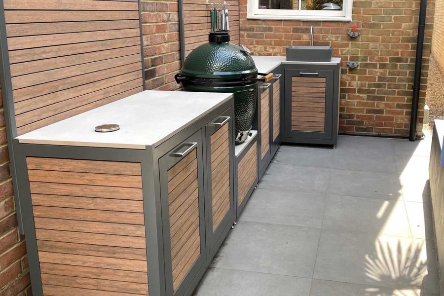 Egg barbecue and outdoor kitchen units, clad with Chestnut composite battens, line side return of house under window.
