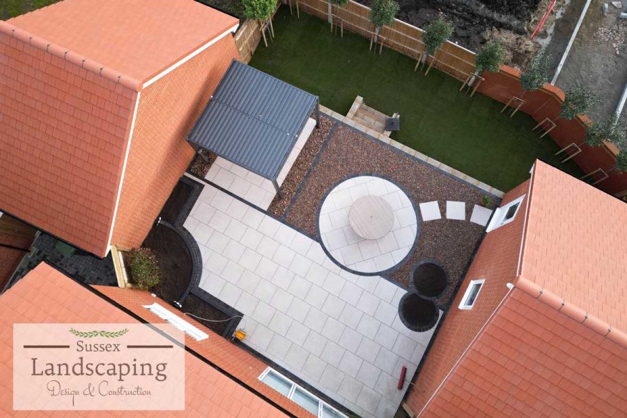 Aerial view of pergola on Florence Grey porcelain paving laid in geometric shapes edged with setts. Design by Sussex Landscaping.