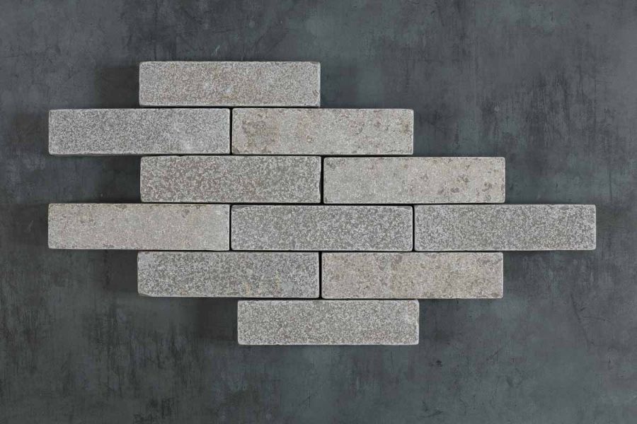 11 Antique Grey limestone patio bricks laid in 6 rows of varying lengths on a dark background. Free UK delivery available.