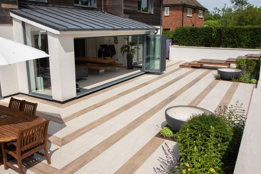Modern house extension with bi-folding doors opening out onto a large porcelain patio of Faro and Rovere porcelain paving.