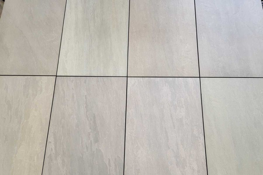 Close-up view of Raj Green Porcelain Paving slabs on pedestals. Experience the varied colour tones and precisely cut edges of these Garden Tiles UK.