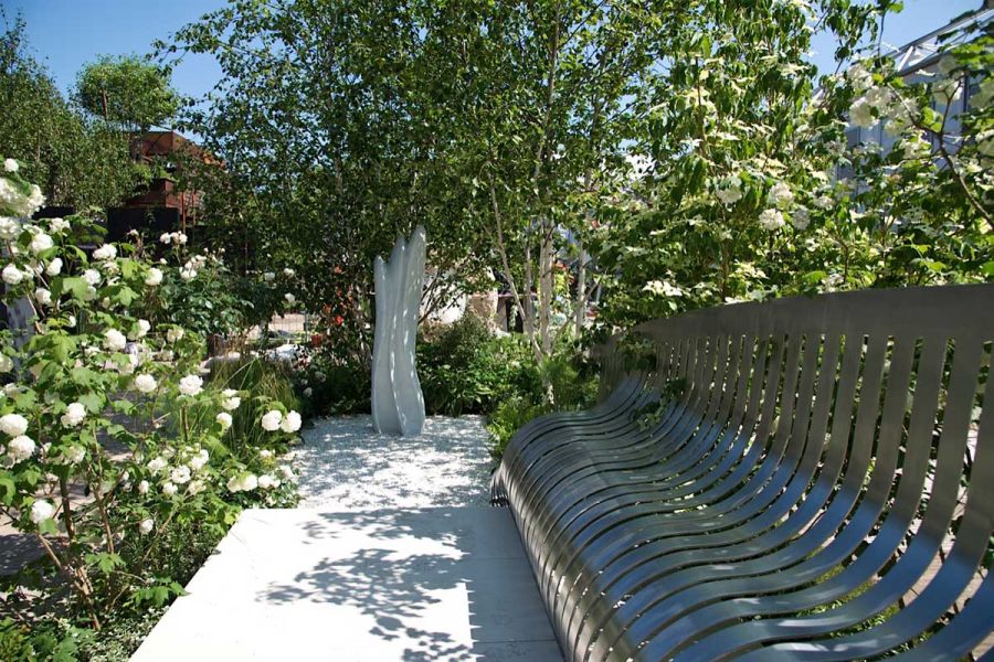 Sandy White Porcelain path flanked by steel bench, sinuous white stone sculpture ahead, in London Square Garden, RHS Chelsea 2014