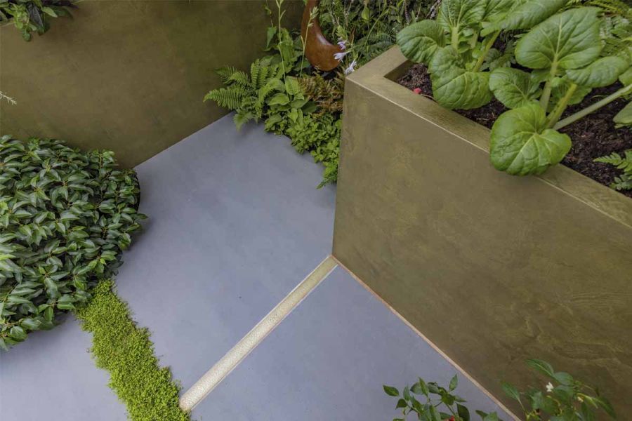Large Patio Slabs laid butt up to Corten steel effect rectangle planters with low level flower beds cut into the paving.