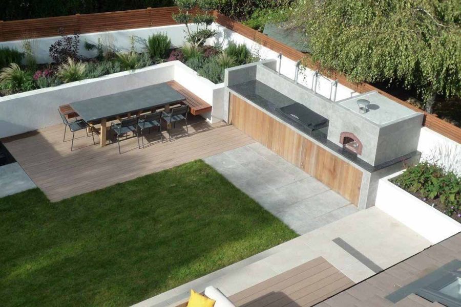 Garden from above, featuring Silver Contro outdoor ceramic tiles, decking, lawn, outdoor kitchen, rendered walls and cedar fencing.