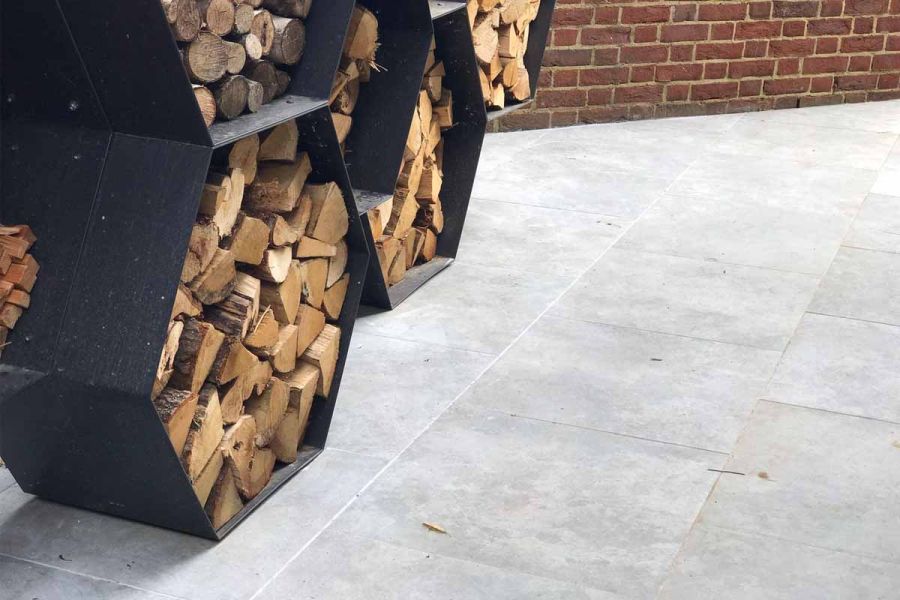 A wood store site on Silver Contro Vitrified Porcelain paving laid in running bond pattern at an oblique angle to a brick wall.