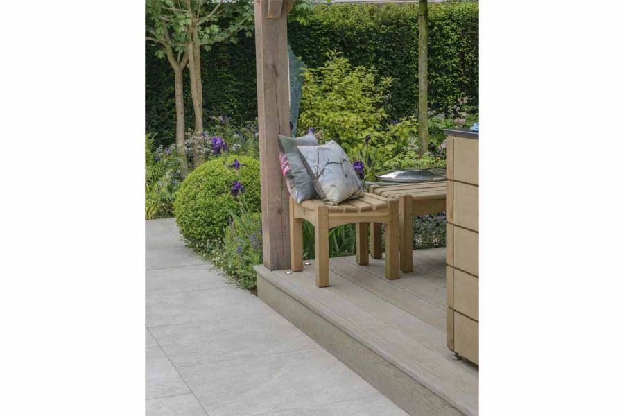 Silver-grey porcelain paving, raised wooden decking and wooden stools on David Harber award-winning trade stand Chelsea 2016.
