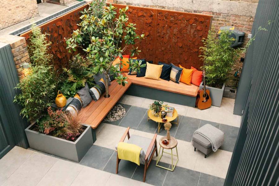 Walled courtyard paved in stripes of Slab Khaki and Slab Coke porcelain paving with a corner bench seat. Design by Georgia Lindsay.
