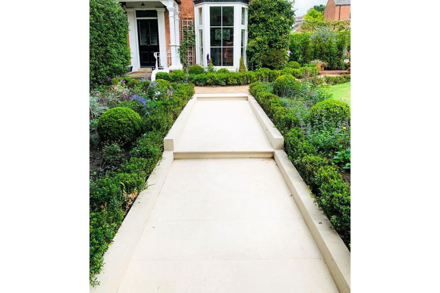 Slab Khaki porcelain path rises to house between beds of low hedges and topiary. By Parme Garden Design. Built by Base Squared.