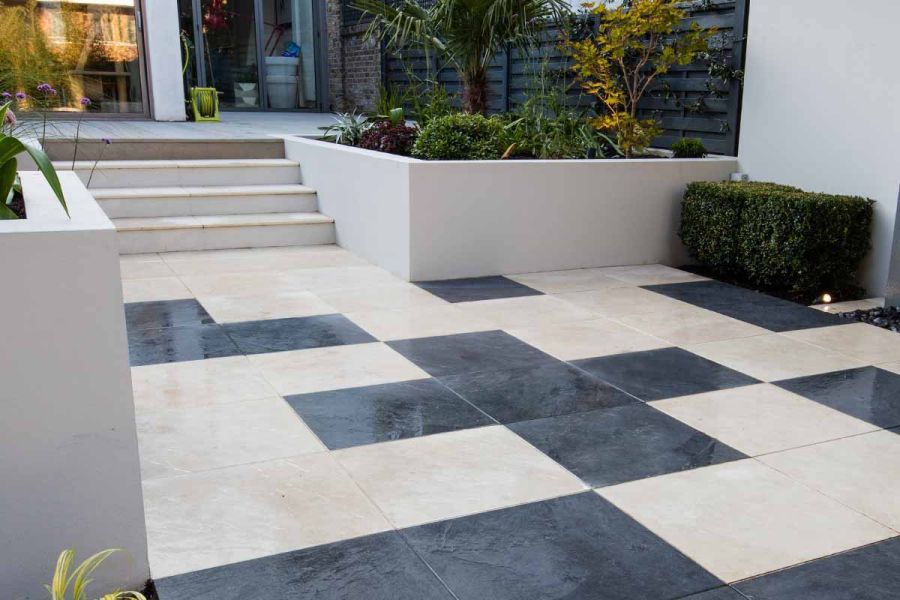 Black and white paving design in 2-level garden with Slab Khaki porcelain 5mm pencil round profiled slabs for steps.