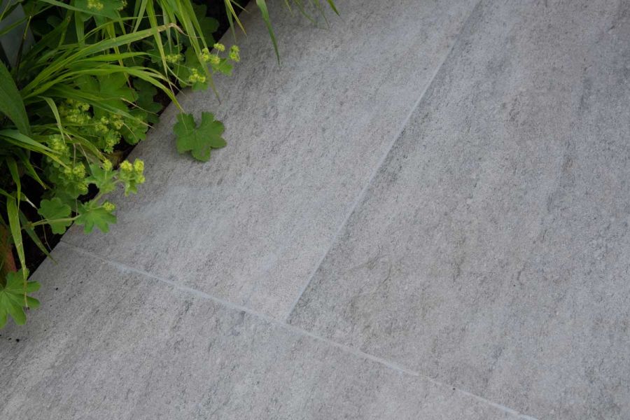Travertine Dark Porcelain Paving Slabs with pale grout, laid by Stewart Landscape Construction, edged with Alchemilla mollis.