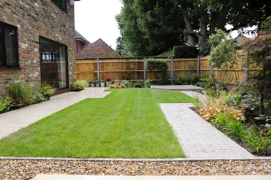 Rectilinear garden design with displaced rectangles of lawn. Paving and Stone Grey clay paving create path and patio areas.