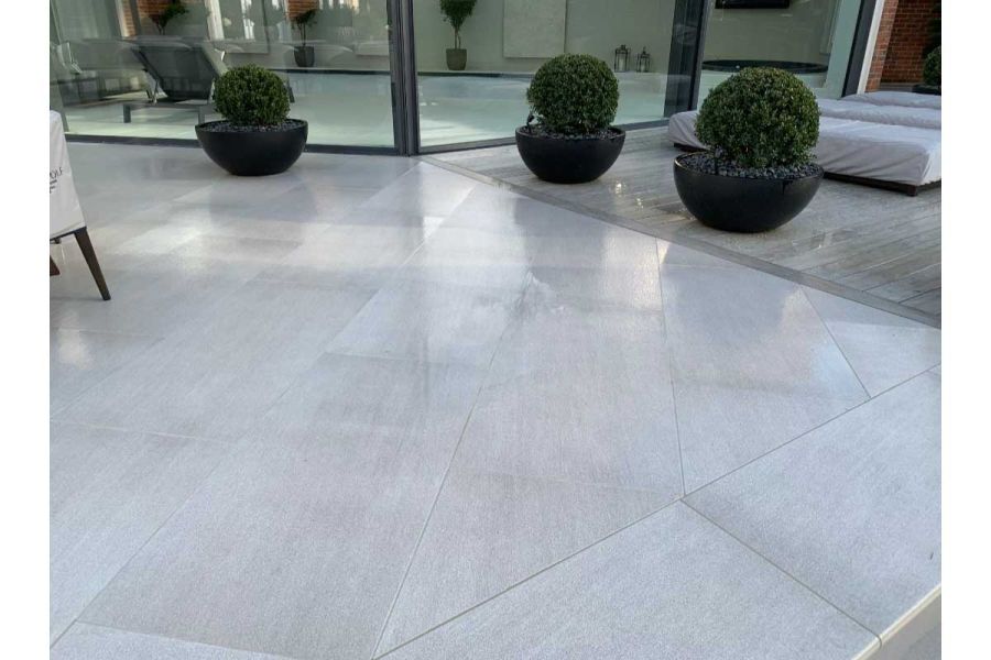 Urban Grey Porcelain paving slabs laid diagonally to Luna DesignBoard, with three pots of topiary. Design by Stone & Webb.