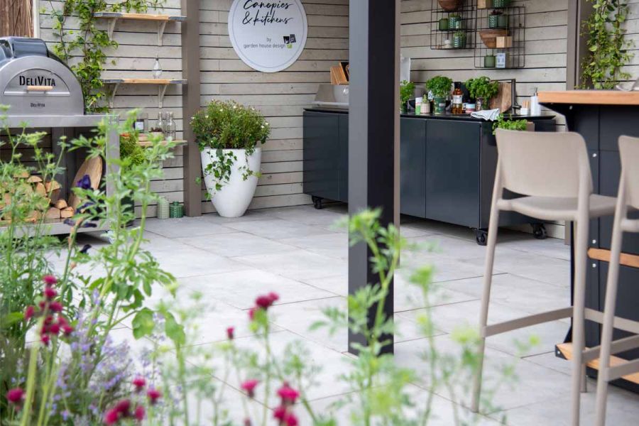 Bar set, planters, pizza oven and cupboard unit on the Garden House Design Trade Stand, paved with Venetian Grey Porcelain tiles.