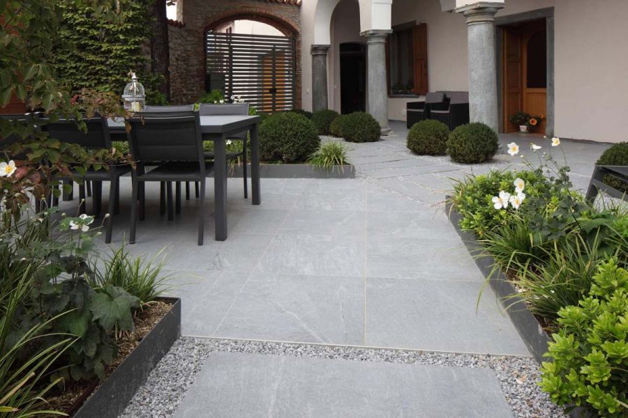 Garden in 600x600mm Versilia Porcelain laid stack bond. Gravel area, with Plank paving and row of topiary balls, leads to loggia.
