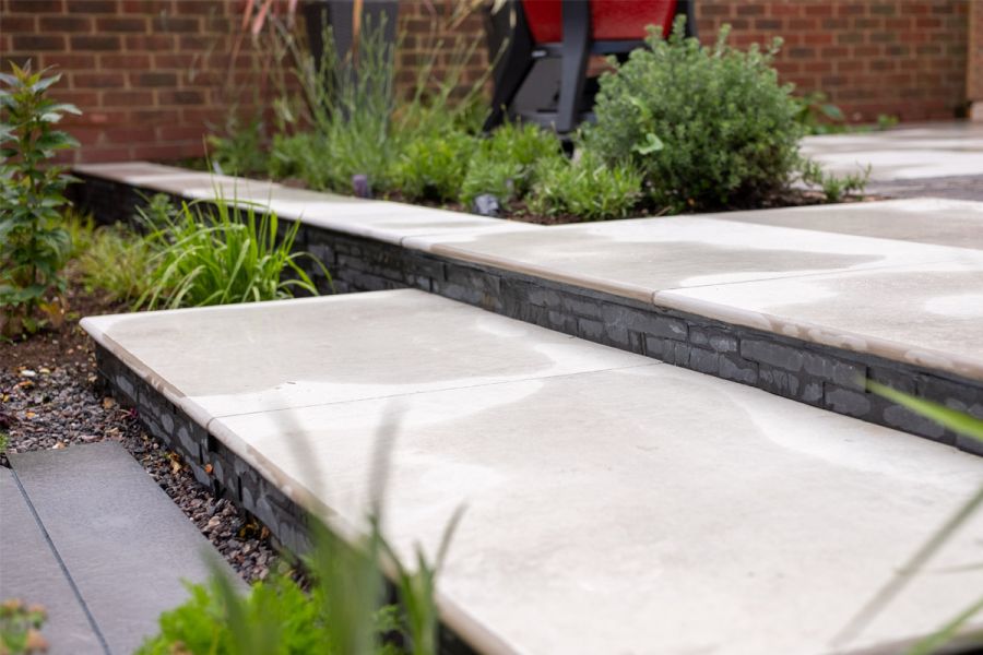 Light Grey Porcelain step treads with a full bullnose finish edge profile and stepping up onto a matching raised porcelain patio.